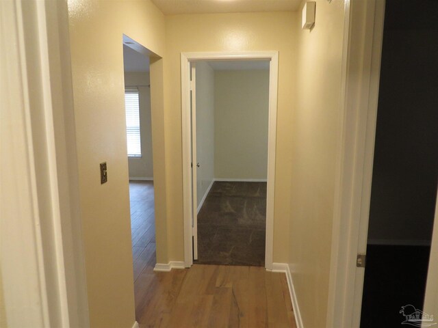 hallway with wood finished floors and baseboards