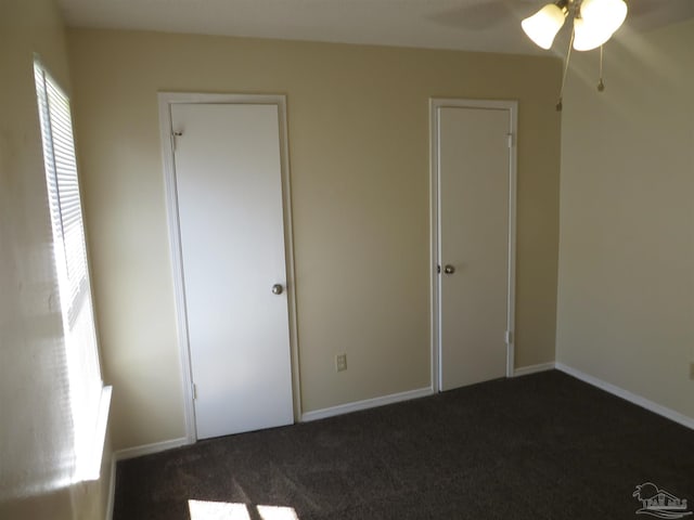 unfurnished bedroom featuring ceiling fan and dark colored carpet