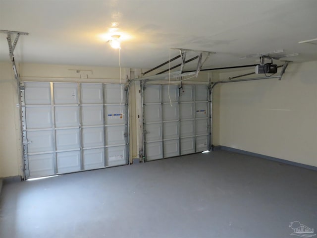 garage featuring a garage door opener and baseboards