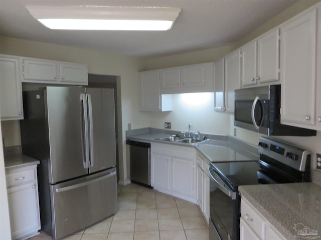 kitchen with white cabinetry, appliances with stainless steel finishes, light tile patterned floors, and sink