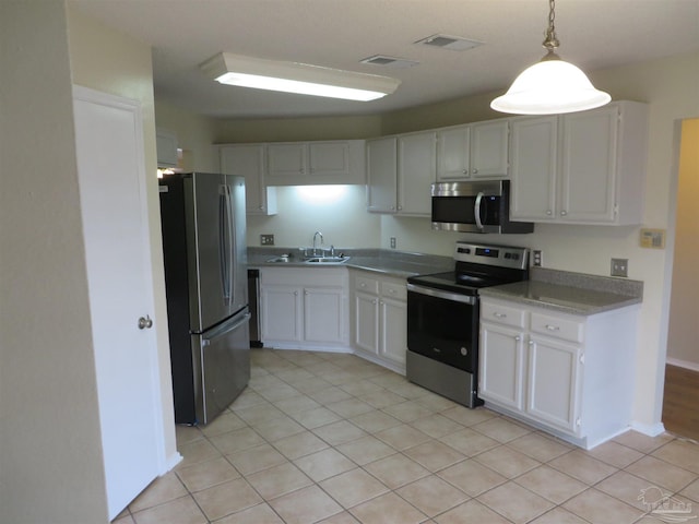 kitchen featuring hanging light fixtures, light tile patterned floors, stainless steel appliances, and white cabinets