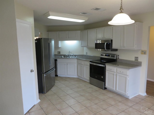 kitchen featuring stainless steel appliances, light tile patterned floors, white cabinets, and visible vents