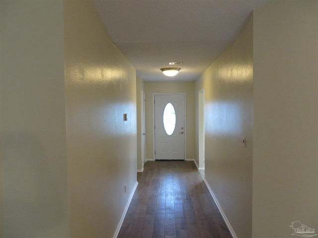 doorway to outside with dark wood-style flooring and baseboards