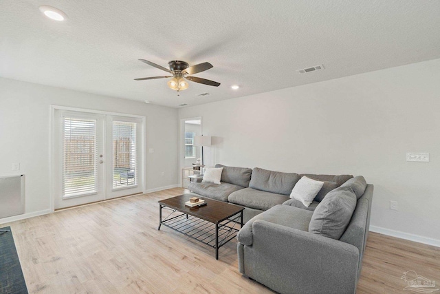 5252 Peach Dr, Pace, FL 32571 - living room featuring a ceiling fan, light wood-type flooring, baseboards, french doors, and a textured ceiling