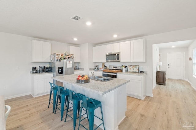 5252 Peach Dr, Pace, FL 32571 - kitchen featuring appliances with stainless steel finishes, a breakfast bar, light wood finished floors, baseboards, and recessed lighting