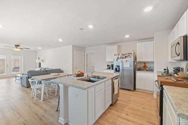 5252 Peach Dr, Pace, FL 32571 - kitchen with a sink, appliances with stainless steel finishes, light wood-style floors, white cabinets, and a ceiling fan