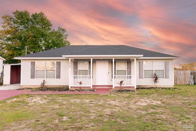 ranch-style home with a porch and a yard