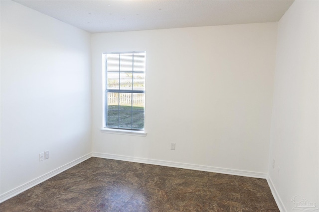 unfurnished room with baseboards