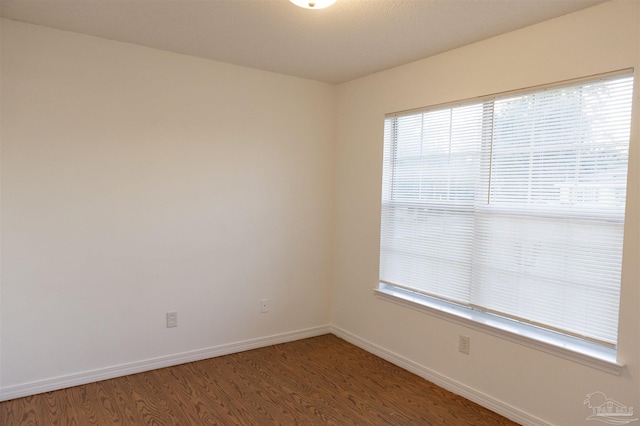 empty room featuring a healthy amount of sunlight, baseboards, and light wood-style flooring