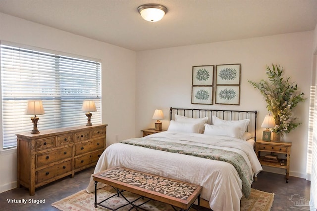 bedroom featuring baseboards and multiple windows