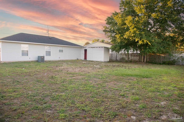 yard at dusk with central AC unit