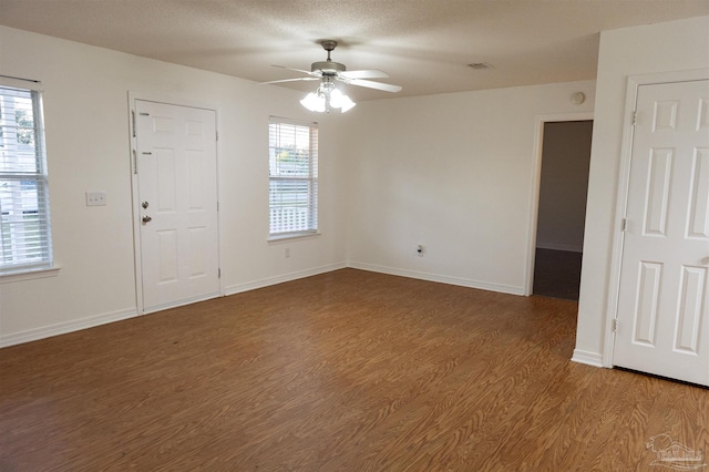 empty room featuring light wood-style floors, ceiling fan, a wealth of natural light, and visible vents