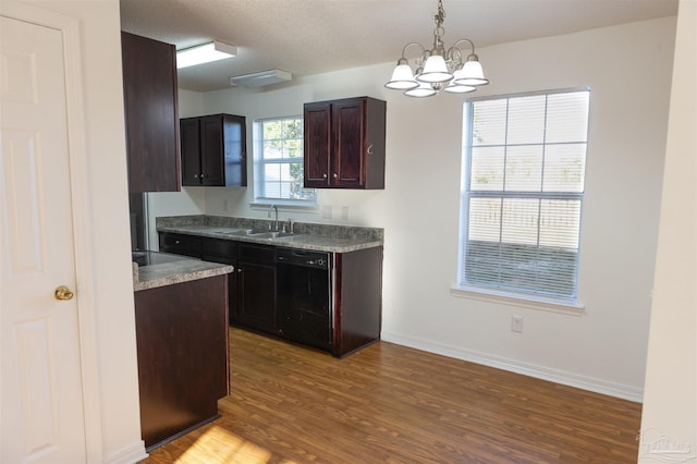 kitchen with a sink, light wood-style flooring, black dishwasher, and a notable chandelier