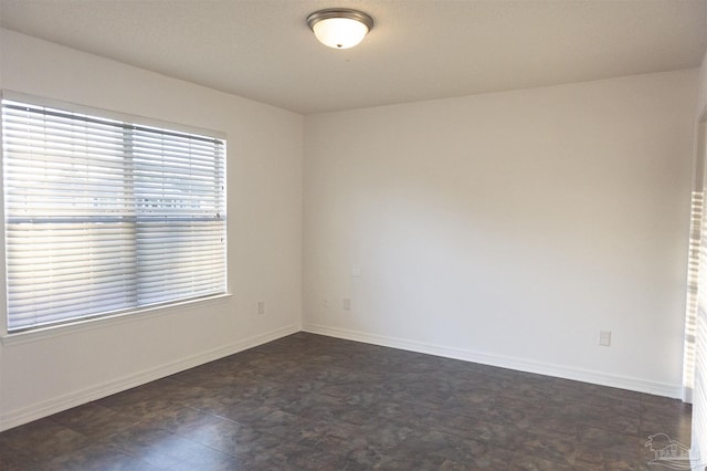 unfurnished room featuring baseboards