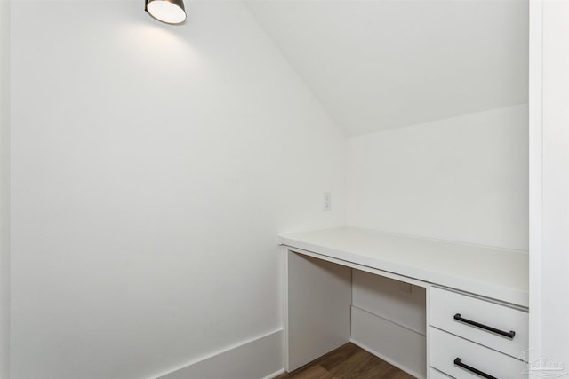 unfurnished office featuring vaulted ceiling and dark wood-style flooring