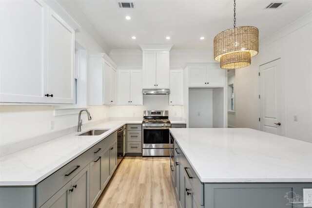 kitchen with light hardwood / wood-style flooring, gray cabinets, stainless steel appliances, hanging light fixtures, and sink