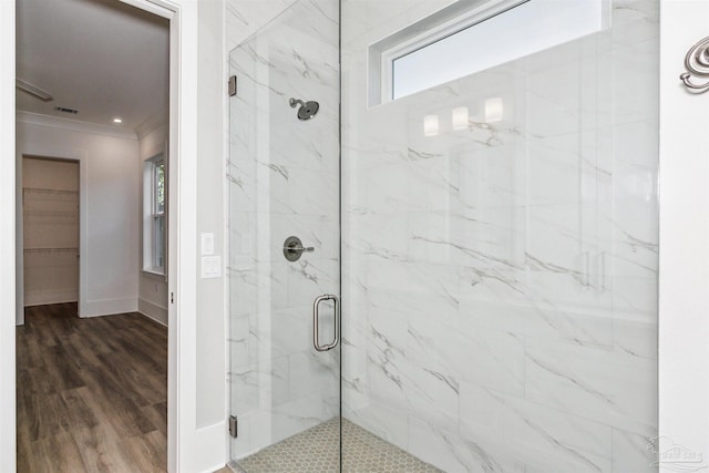 bathroom featuring crown molding, a marble finish shower, visible vents, wood finished floors, and baseboards