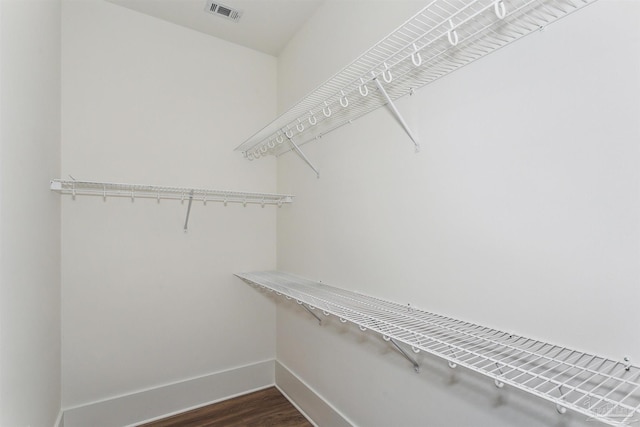 walk in closet featuring visible vents and dark wood finished floors