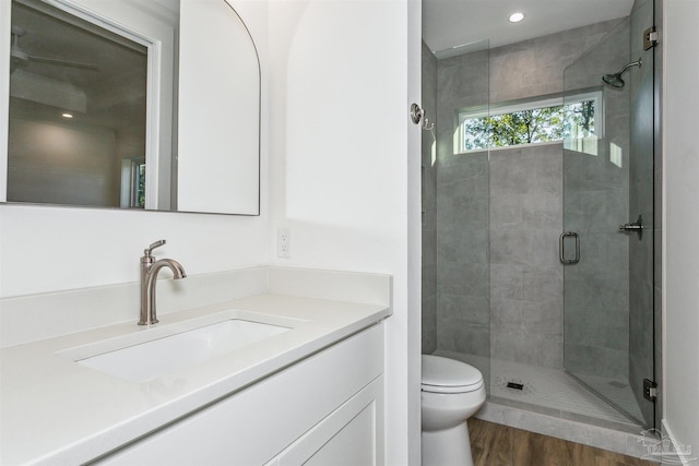 bathroom featuring a stall shower, vanity, toilet, and wood finished floors