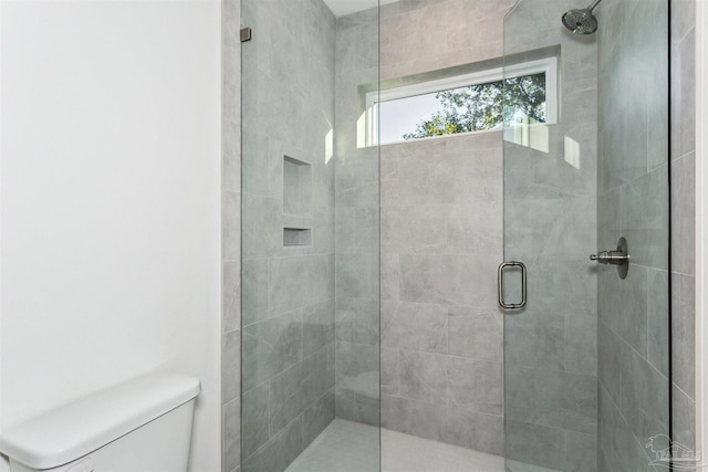 bathroom with a shower stall and toilet