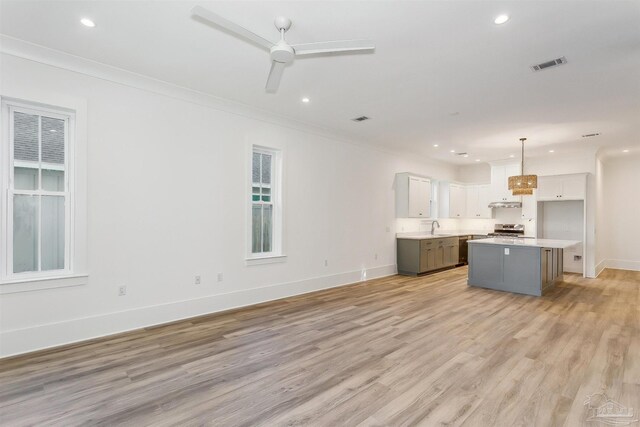 kitchen featuring white cabinetry, a center island, ceiling fan, light hardwood / wood-style floors, and pendant lighting