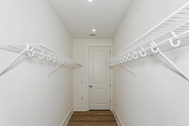 walk in closet featuring visible vents and dark wood-type flooring