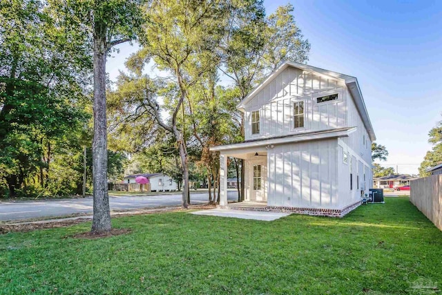 view of front of property featuring a front yard, fence, and central air condition unit