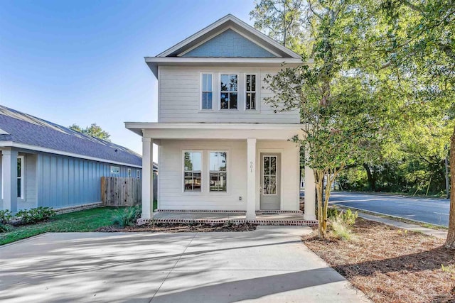 view of front of home featuring covered porch and fence