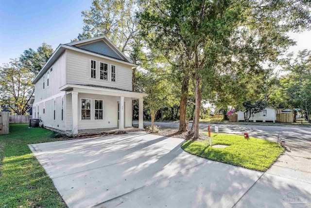 view of front facade featuring driveway, central air condition unit, and a front yard