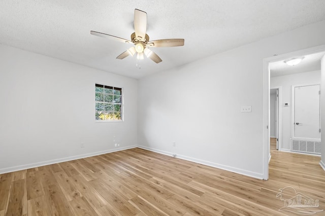 spare room featuring ceiling fan, a textured ceiling, and light wood-type flooring