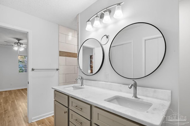 bathroom with wood-type flooring, a textured ceiling, ceiling fan, and vanity