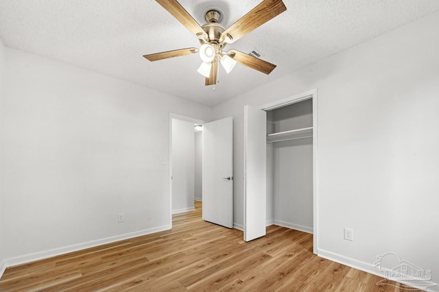 unfurnished bedroom featuring a closet, ceiling fan, light hardwood / wood-style flooring, and a textured ceiling