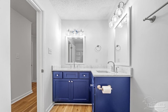 bathroom featuring wood-type flooring, a textured ceiling, and vanity