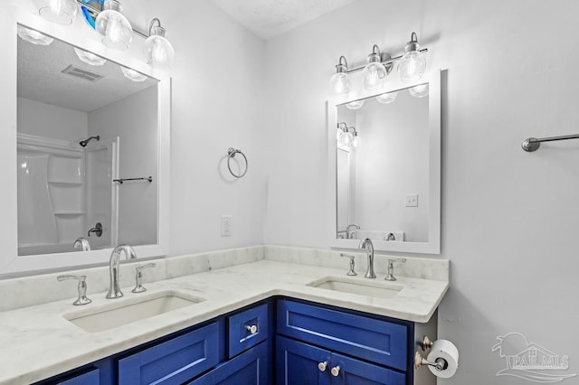 bathroom featuring vanity, bathtub / shower combination, and a textured ceiling