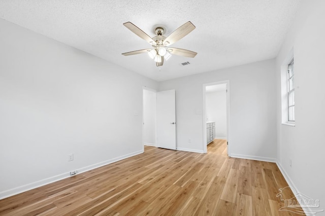 unfurnished bedroom featuring ceiling fan, light hardwood / wood-style floors, and a textured ceiling