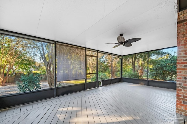 unfurnished sunroom featuring ceiling fan and a wealth of natural light