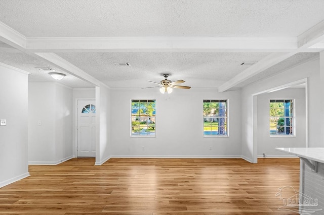 unfurnished living room with ceiling fan, wood-type flooring, a textured ceiling, and beamed ceiling