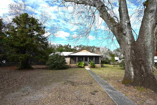 ranch-style home featuring a front lawn and a sunroom