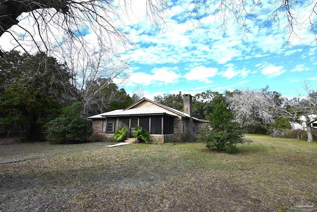 view of front facade with a sunroom and a front lawn