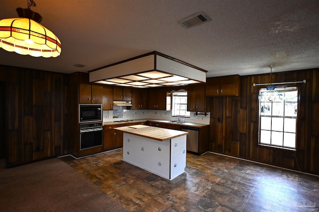 kitchen with a center island, a wealth of natural light, pendant lighting, and appliances with stainless steel finishes