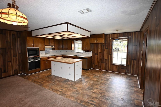 kitchen with decorative light fixtures, black microwave, wall oven, and a healthy amount of sunlight