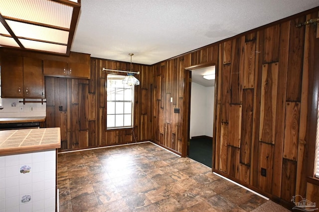 interior space featuring a textured ceiling and wooden walls