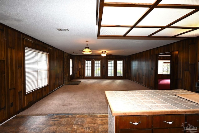 kitchen featuring a textured ceiling, dark colored carpet, ceiling fan, and dark brown cabinetry