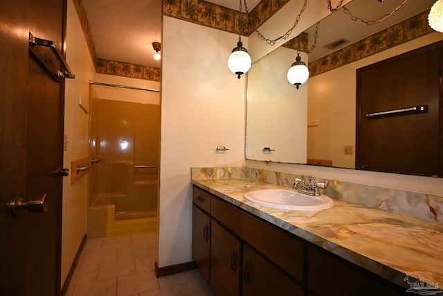 bathroom with vanity, tile patterned floors, and a shower