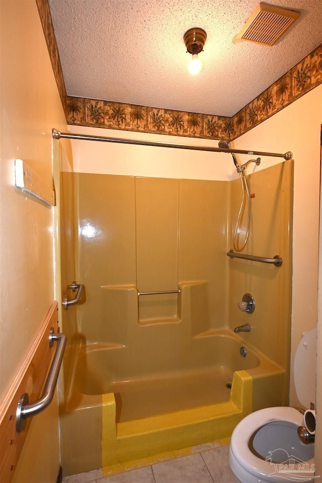 bathroom featuring toilet, tile patterned flooring, a textured ceiling, and  shower combination