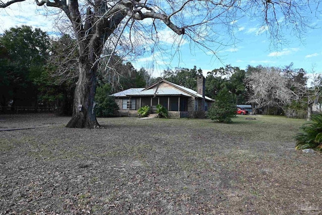 view of front of house with a front lawn and a sunroom