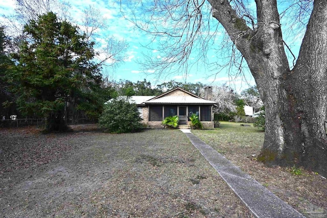 ranch-style home with a front lawn and a sunroom