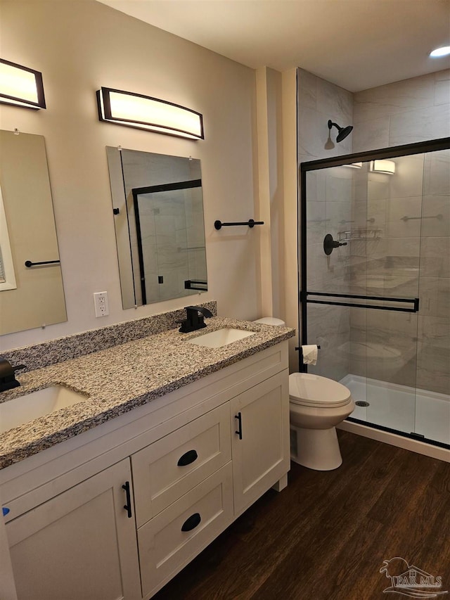 bathroom featuring toilet, vanity, wood-type flooring, and walk in shower