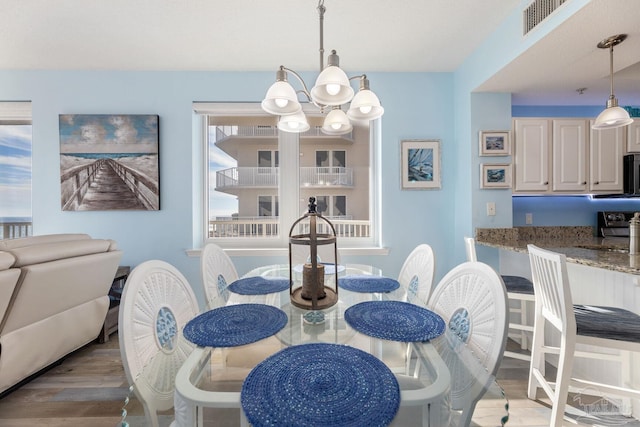 dining space with hardwood / wood-style flooring and an inviting chandelier