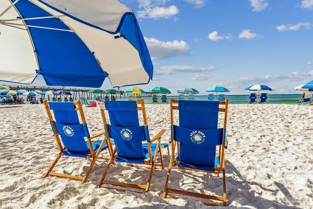 surrounding community with a water view and a view of the beach